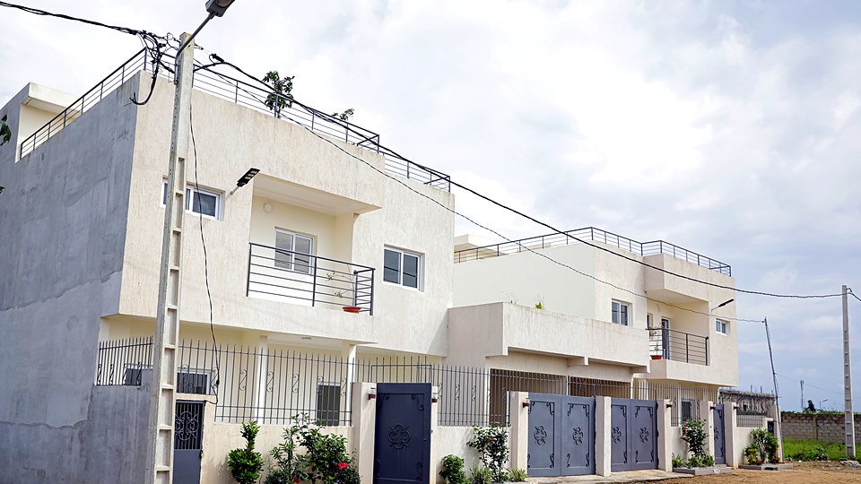 Les deux duplex jumelés de Songon Kassemble vus depuis la rue, avec le retrait qui sépare les deux volumes.